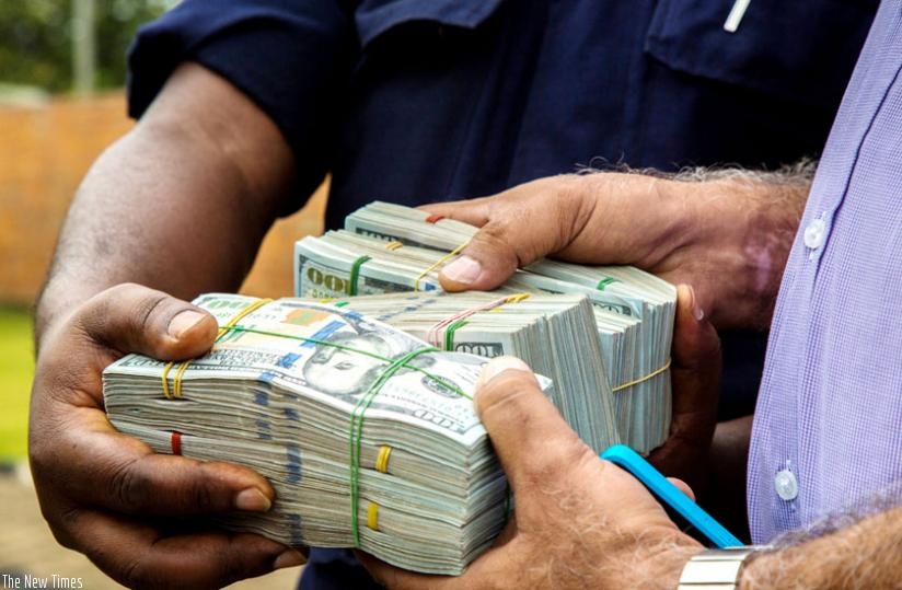 Police hand over recovered money to Somji in Kigali yesterday. (Timothy Kisambira)