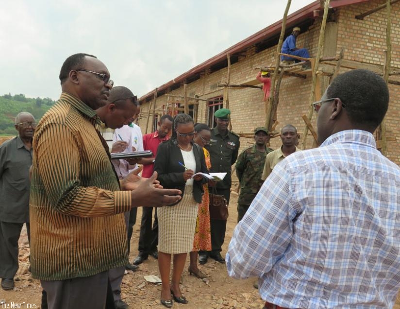 Minister Kanimba (L) chats with Gisagara officials at the construction site for the  proposed facility. (E. Ntirenganya)