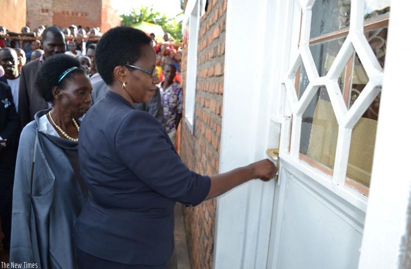 WDA's  Abakunzi opens the door to the  house that IPRC- East donated to Muhorakeye (L). (S. Rwembeho)