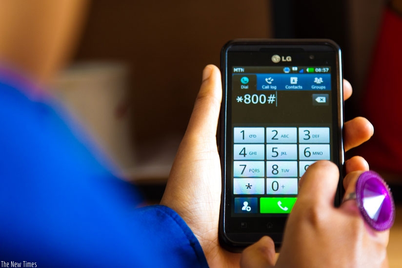 An MTN Rwanda subscriber dials one of the service codes. (Timothy Kisambira)