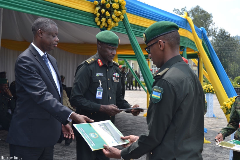Kabarebe hands over a certificate to Major Francois-Regis Gatarayiha, the student with  best research  paper. (Jean d'Amour Mbonyinshuti)