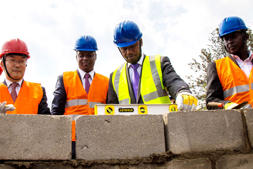 The Minister of State in charge of Technical and Vocational Education and Training (TVET), Albert Nsengiyumva (2nd R), lays a block  at the groundbreaking ceremony for the construction of a teacher training institute at Kicukiro, as Choongsik Han, the senior vice president of Korean International Cooperation Agency (L), the Principal of IPRC Kigali, Eng. Diogene Mulindahabi (2nd L), and Kicukiro mayor Paul Jules Ndamage look on yesterday. (All photos by Timothy Kisambira)