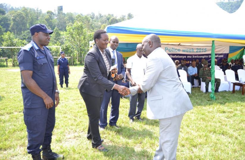 Minister Uwacu hands over a cheque to the head of a fishing cooperative in Rubavu as IGP Gasana looks on, yesterday. (Courtesy)