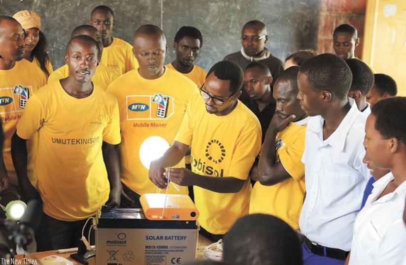 A technician from Mobisol demostrates to MTN staff and students from Ecole Secondaire Gasange how the solar equipment works.  (Courtesy)