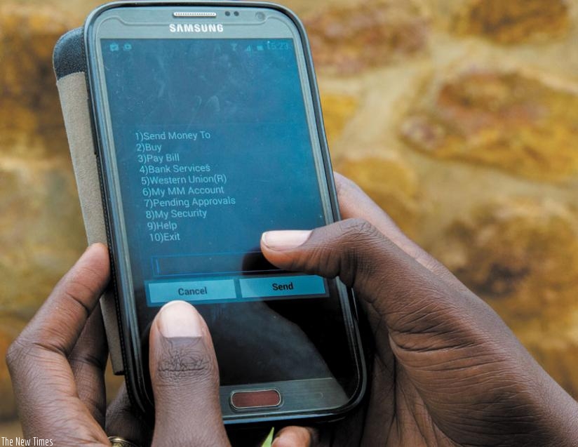 An MTN Mobile Money subscriber checks balance on a mobile phone. Rwandans living abroad will be able to send money directly to their relatives' mobile phone following a partnership deal between MTN and Western Union. (Doreen Umutesi)