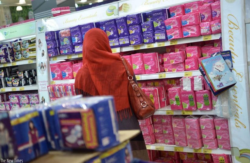 A lady in the sanitary pads section of supermarket. Most women and girls still struggle to pay a minimum of RwF600 for pads. (Net photo)