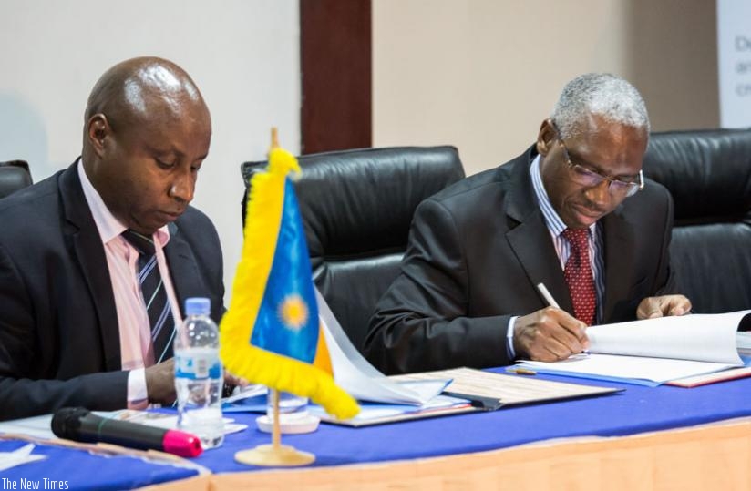 Mugiraneza (L) and Tuyaga sign the memorandum of understanding yesterday. (Timothy Kisambira)