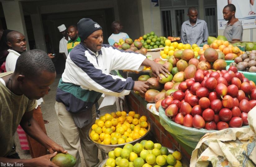 A vendor sorts fruits in Kimironko market. Small business operators like him say licence fees are high. (File)