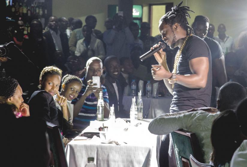 Ugandan star Bebe Cool abandons the stage and gets up close with a female fan at the fashion show. (Doreen Umutesi)