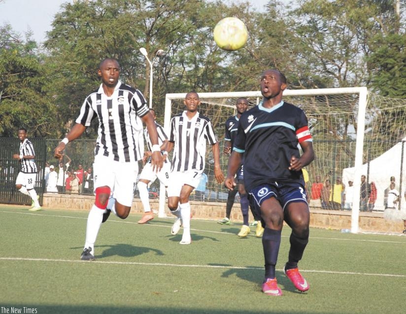 Police defender Fabrice Twagizimana (R) attempts to clear the ball against APR skipper Ismail Nshutiyamagara during the first leg. The second leg ended 0-0 yesterday to send Police to the final. (Peter Kamasa)