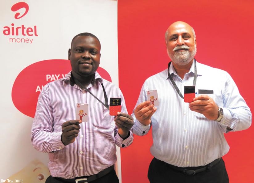Head of Airtel Money Stephen Waiswa and Bhullar show off the new e-payment devices.