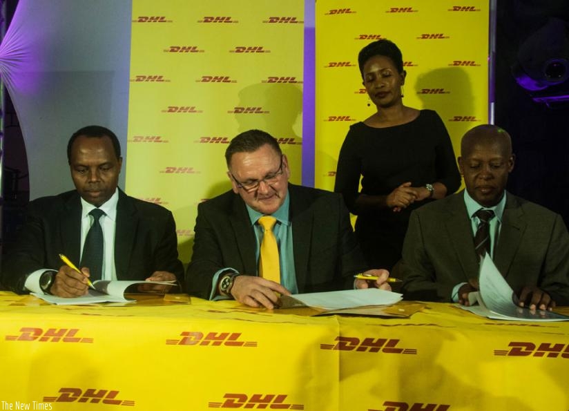 RDB's Gatare, Brewer and Silas Udahemuka, the director general of Rwanda Civil Aviation Authority, sign the agreement in Kigali last week. DHL is going to start construction works on a modern logistics facility at Kigali International Airport next month. (Teddy Kamanzi)