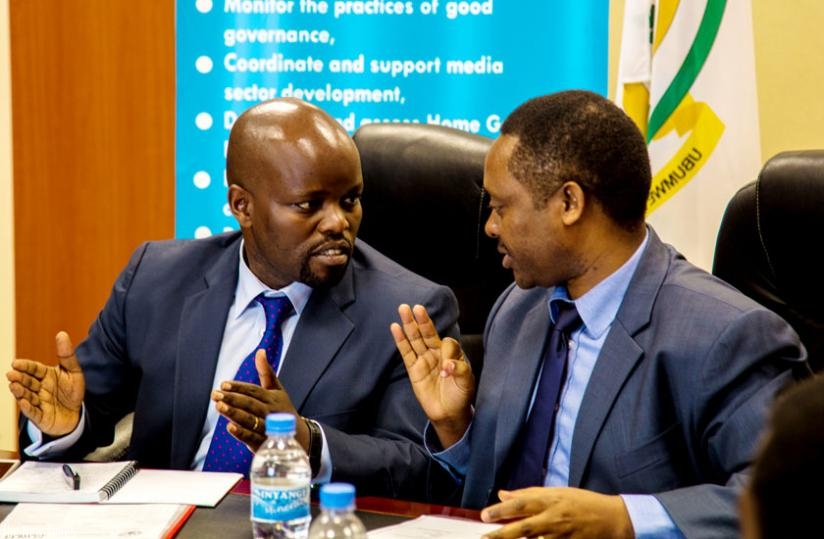 Youth and ICT minister Jean Philbert Nsengimana (L) and Prof Anastase Shyaka, the Rwanda Governance Board chief executive, exchange ideas after signing the agreement between the board and stakeholders for Mobile Application competition on e-Governance. (Doreen Umutesi)