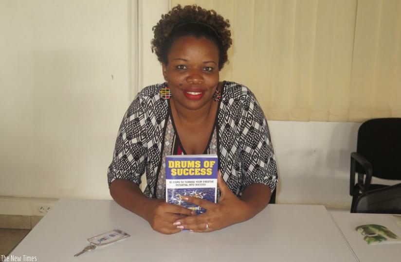Umwagarwa with a copy of her book, Drums of Success.