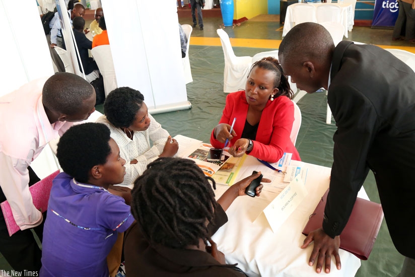 Job-seekers speak with a potential employer at the job fair in Remera, Kigali recently. (File)