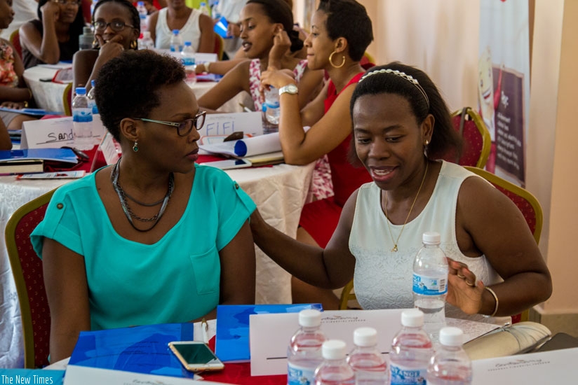 Bank of Rwanda Vice Governor Dr Monique Nsanzabaganwa (R) shares a light moment with Eve Tushabe, an entrepreneur, during a meeting organised by New Faces New Voices to equip women with entrepreneurship skills yesterday. (Doreen Umutesi)