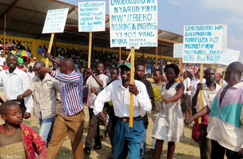 some of the residents of Busasamana march with placards calling for Article 101's amendment at Nyanza Stadium before the debate on Saturday.  (Emmanuel Ntirenganya)