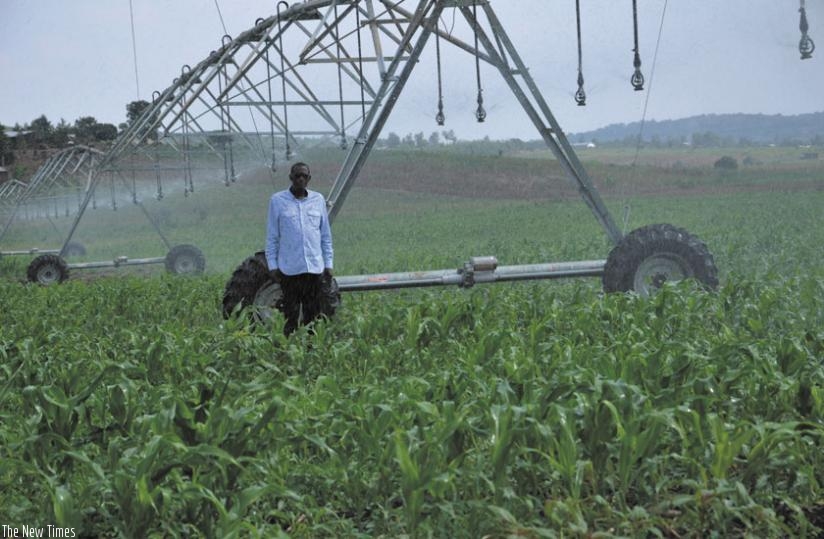 A commercial farmer stands next to an irrigation system he uses to water his crops.