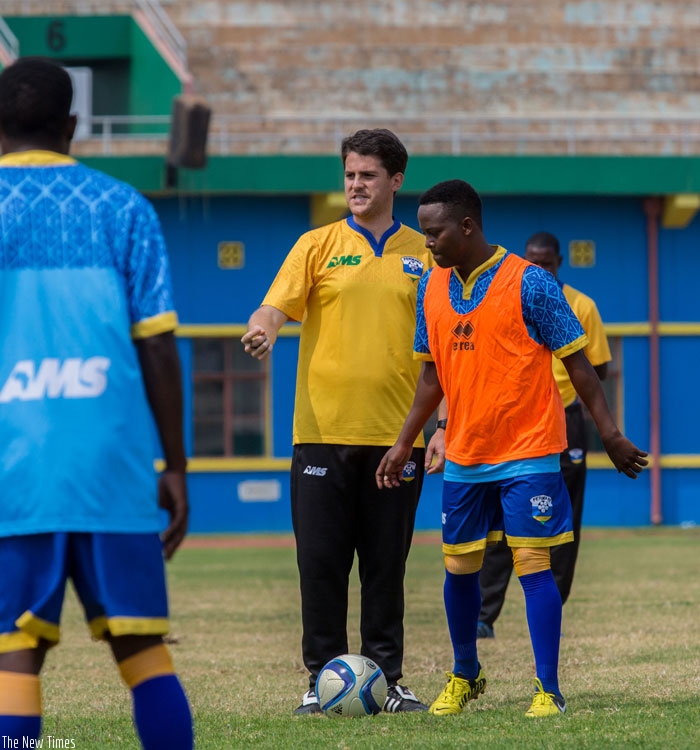 Right back Jean Marie Rukundo listens to Amavubi coach Johnny McKinstry during  training last week. (Timothy Kisambira)