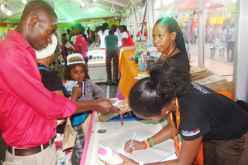 A customer pays for products at a past expo in Kigali. (Net photo)