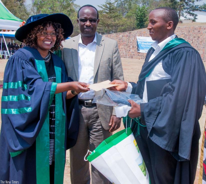 Dr Nyinawamwiza (L) awards Marc Semunyana, the best performing student, during the ceremony.(Teddy Kamazi)