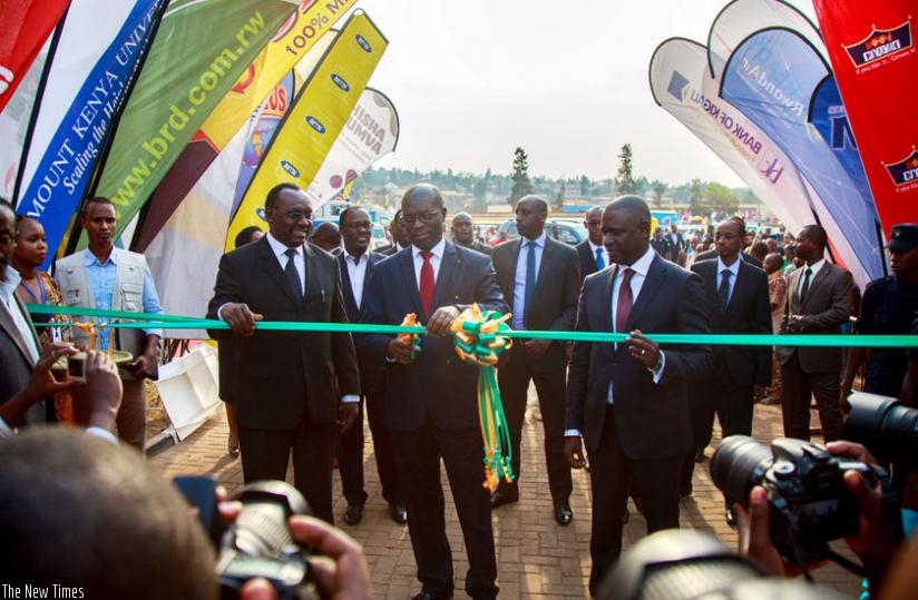 Prime Minister Anastase Murekezi (C), flanked by Trade and Industry minister Francois Kanimba (L) and Benjamin Gasamagera, the chairperson of Private Sector Federation, cuts a ribbon to open the 18th Rwanda International Trade Fair at Gikondo expo ground in Kicukiro District yesterday. (Timothy Kisambira)