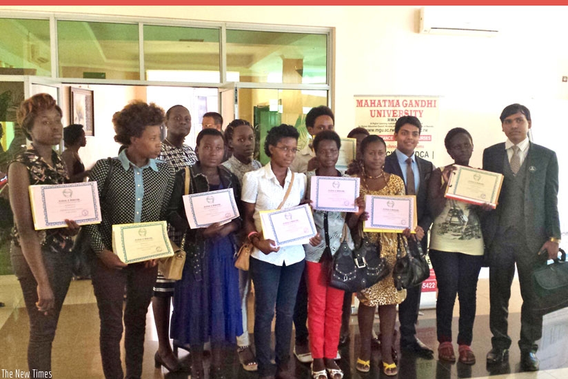 The beneficiaries of the Mahatma Gandhi University Rwanda campus scholarships pose with their certificates in a group photo with officials. (Courtesy)