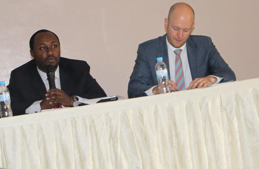 Evode Imena, the minister fo state in charge of mining giving opening remarks as Tyler Gillard, the OECD Head of Sector Projects and Legal Advisor, takes some notes. (Jean Mugabo)