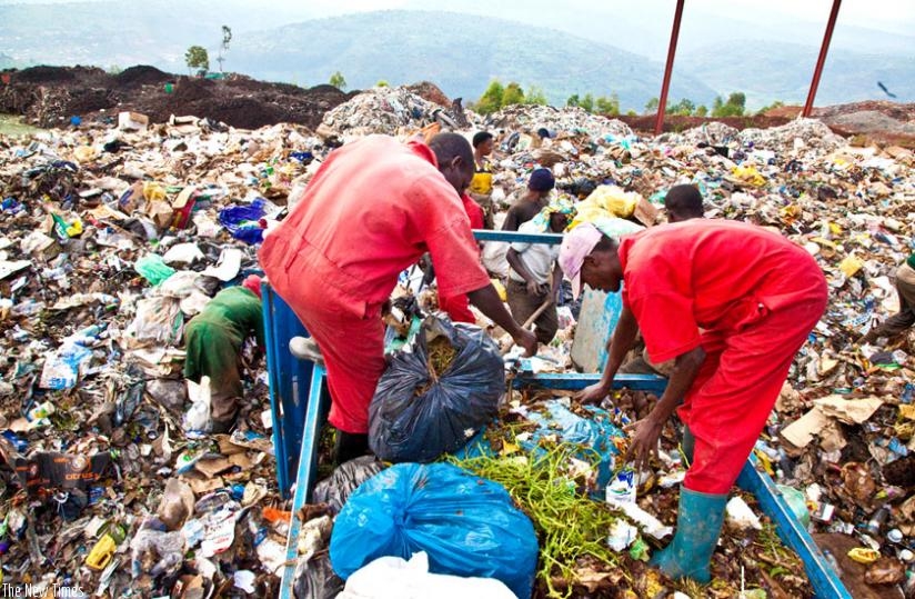 Workers at Nduba Dump Site in Gasabo District sort garbage. (Timothy Kisambira)