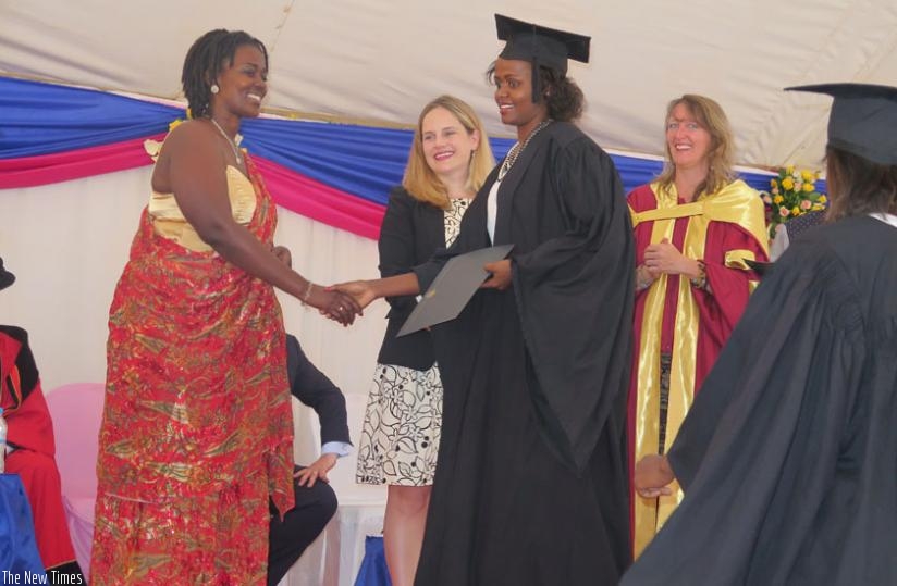 A graduate receives her diploma at the ceremony yesterday. (Solomon Asaba)