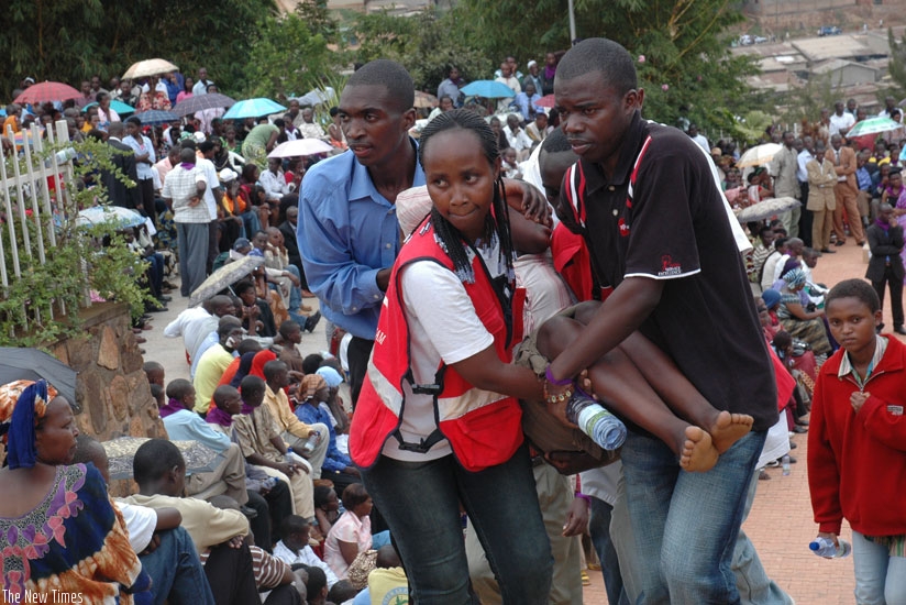 Officials carry a child who collapsed during a past commemoration of the genocide against the Tutsi in Kigali. A 2009 study established that 29 percent of Rwandans had symptoms of chronic Post Traumatic Stress Disorder. (File)