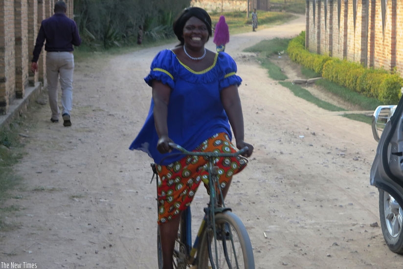Uzabakiriho rides her  bicycle in Byimana Sector, Ruhango.  (Emmanuel Ntirenganya)
