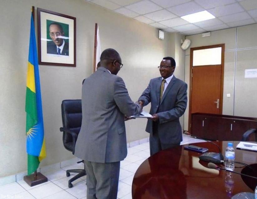 Gatera (L) receives documents from Dr Ufitikirezi during the hand-over ceremony in Kigali on Wednesday. (Eddie Nsabimana)