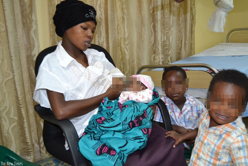 Kankindi breastfeeds her new baby at Kacyiru Police Hospital as two of her other toddlers look on. (Courtesy)