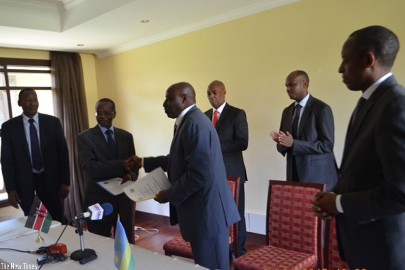 Inspector General of Police (IGP) Emmanuel K. Gasana exchanges documents with his Kenyan counterpart, Joseph K. Boinnetu200e.