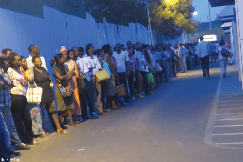 Passengers wait for Kimironko buses at 7pm at a downtown bus terminal last week.The first person and the last on the queue boarded buses at the same time as five buses thronged terminal within seconds of each others.  (Jean Mugabo) 