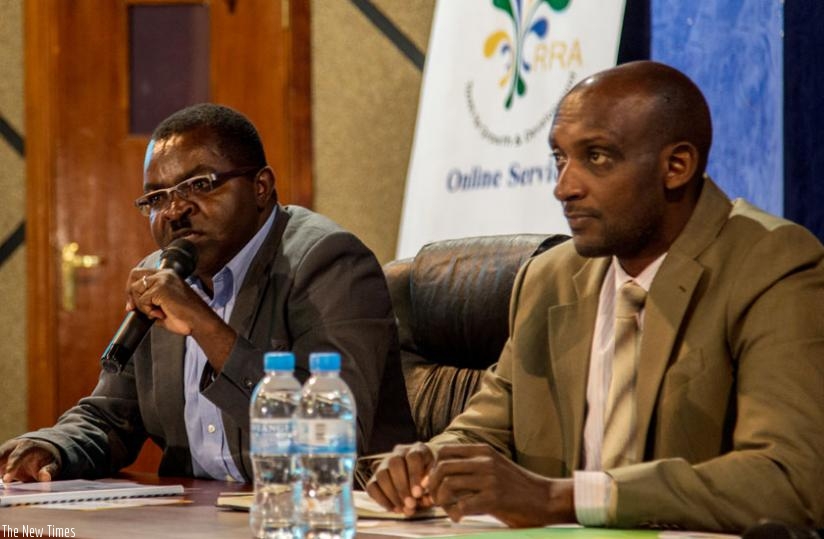 (L-R) The Permanent Secretary of the Ministry of Local Government Vincent Munyeshyaka speaks at the launch of Rwanda Automated Local Government Taxes Management Systems while Richard Tushabe, Rwanda Revenue Authority Commissioner General, looks on. (Doreen Umutesi)