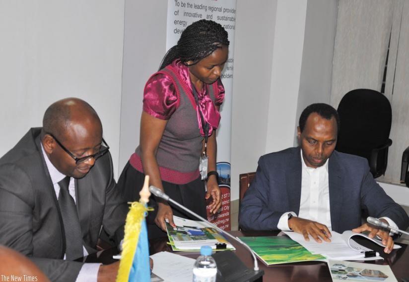 RDBu2019s Francis Gatare signs the lease deals as Minister Musoni looks on. (P. Tumwebaze)