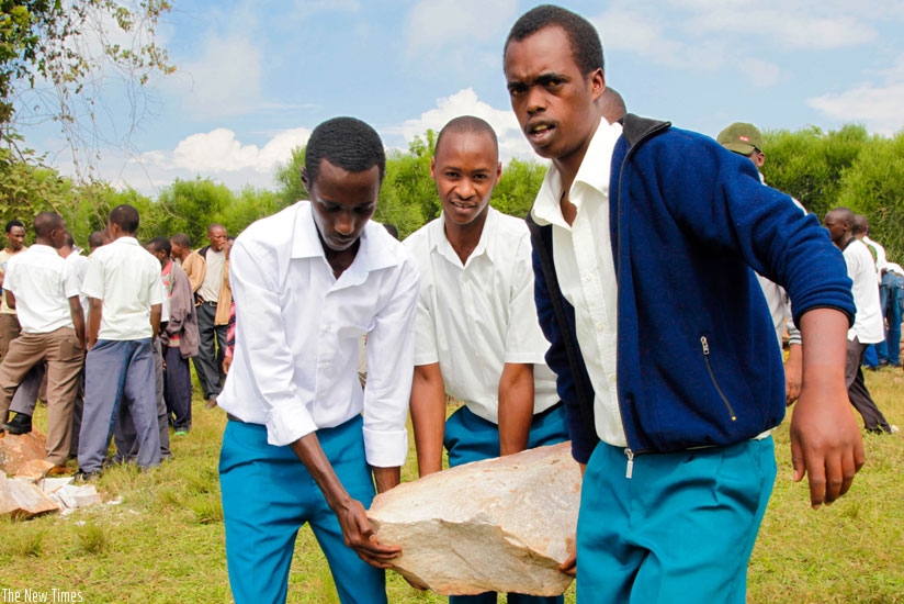 Students carry a stone during the Umuganda activity to construct a classroom block in Gatsibo. (T. Kisambira)