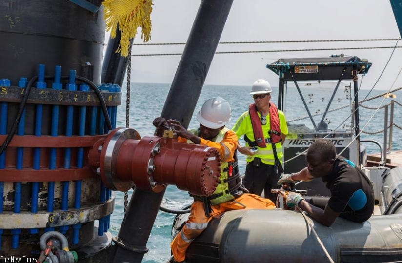 Workers fix equipment at KivuWatt Methane Project plant on Lake Kivu last week. (Timothy Kisambira)
