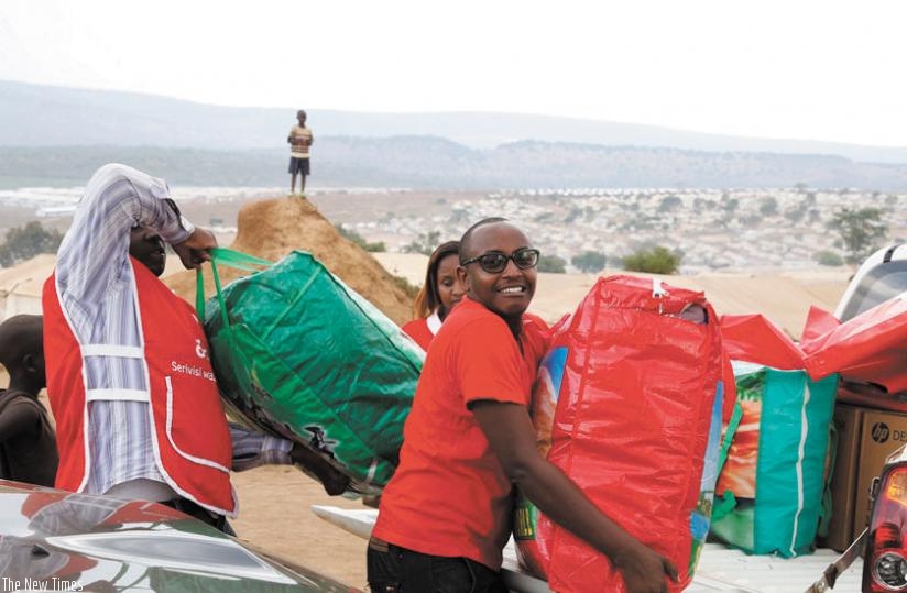 Airtel Rwanda staff unload some of the relief items the telecom firm donated to refugees in Mahama camp. The camp hosts over 43,000 refugees. (Courtesy)
