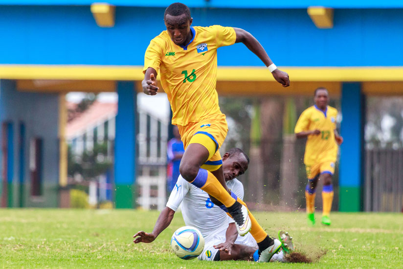 Ernest Sugira beats Gabonese defender Kabi Tchen Djesnot  on the ball during yesterday's  friendly game at Amahoro Stadium. (Timothy Kisambira)