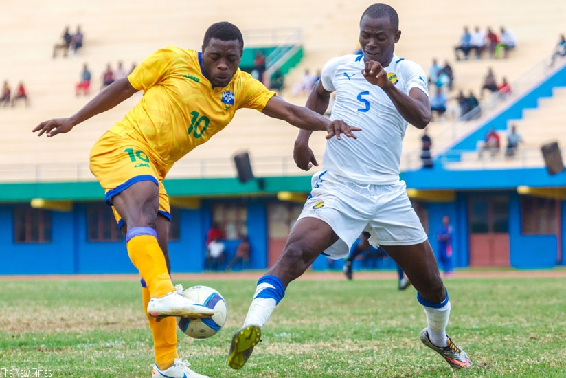 Amavubi debutant Songa (L), tries attempt on goal which is blocked by a Gabonese defender on Saturday. (Timothy Kisambira)