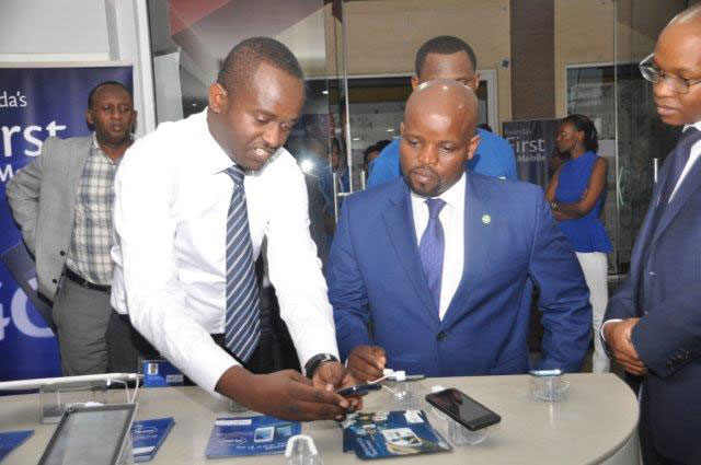 Nsengimana admires one of the smartphones at the launch of the service. (Peterson Tumwebaze)