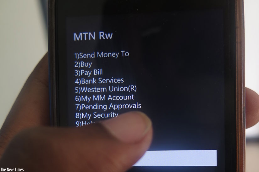A mobile money service subscriber follows procedures to send money. (Solomon Asaba)