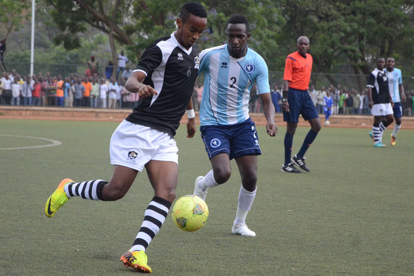 APR FC midfielder Yanick Mukunzi charges past Imran Nshimiyimana of Police during the league match yesterday at Kicukiro stadium. (Samuel Ngendahimana)