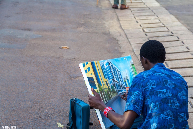 An artist drawing the street. There are many artists along the street. (Timothy Kisambira)