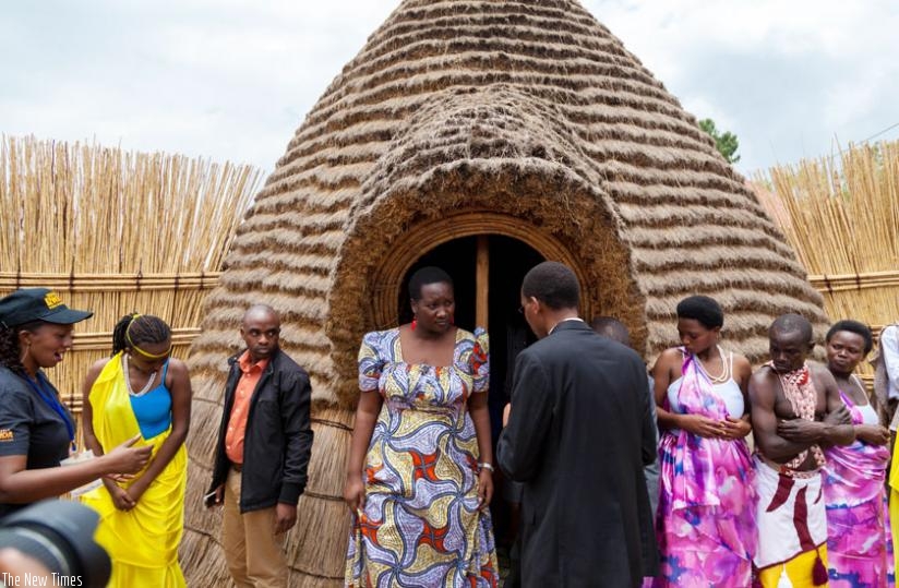 Sports and Culture minister Julienne Uwacu (L) is briefed by Philbert Musanganya, the head of Rulindo Cultural Centre, as she emerges from a tour of one of the traditional houses at the centre. (Timothy Kisambira)