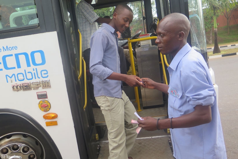 A KBS conductor gives a passenger a ticket at MINIJUST stage, Kimihurira. Passengers will soon start paying bus fares using swipe cards. (Jean Mugabo)