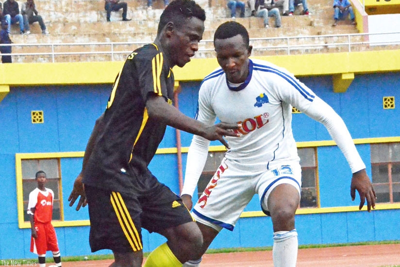 Rayon Sports defender James Tubane (R) tries to stop a Mukura forward during a league game last season. (File)